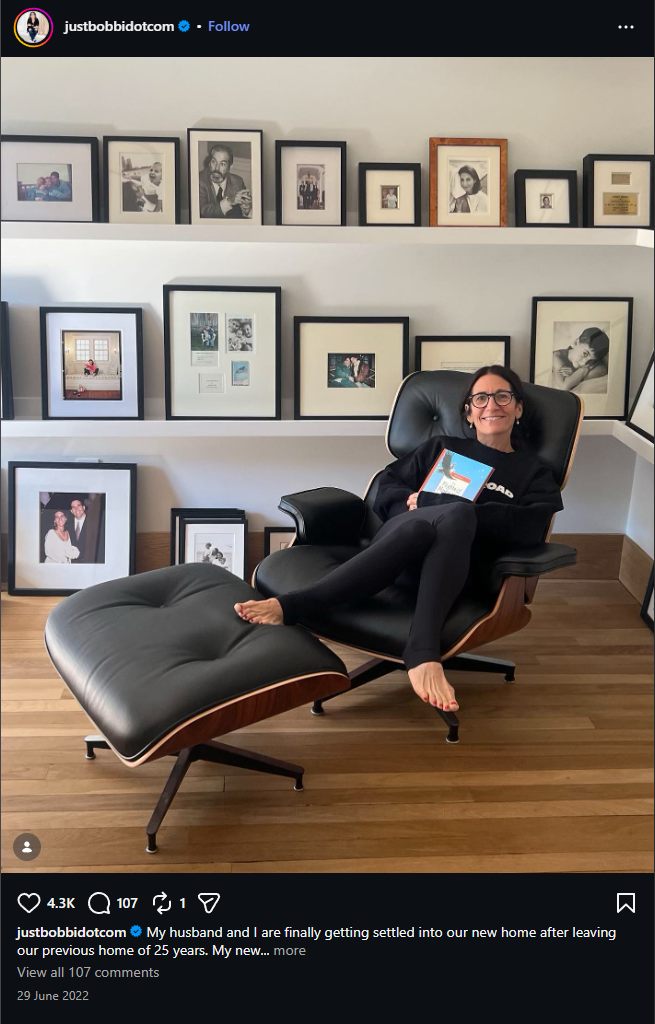 Bobbi Brown Instagram post, June 29, 2022: Bobbi in the same lounge chair in front of the same picture shelves, caption about settling into a new home after leaving a previous home of 25 years.